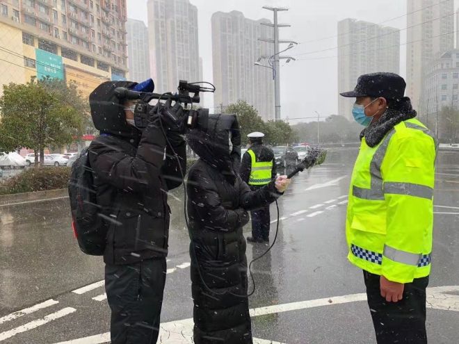 孝感市融媒體中心楊亞玲（風(fēng)雪中，采訪疫情期間重返一線的退休警察）_副本.jpg.jpg
